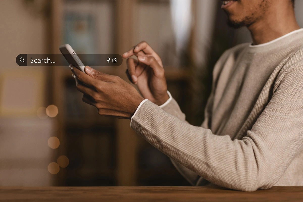 pessoa negra com um celular na mão fazendo uma pesquisa no Google